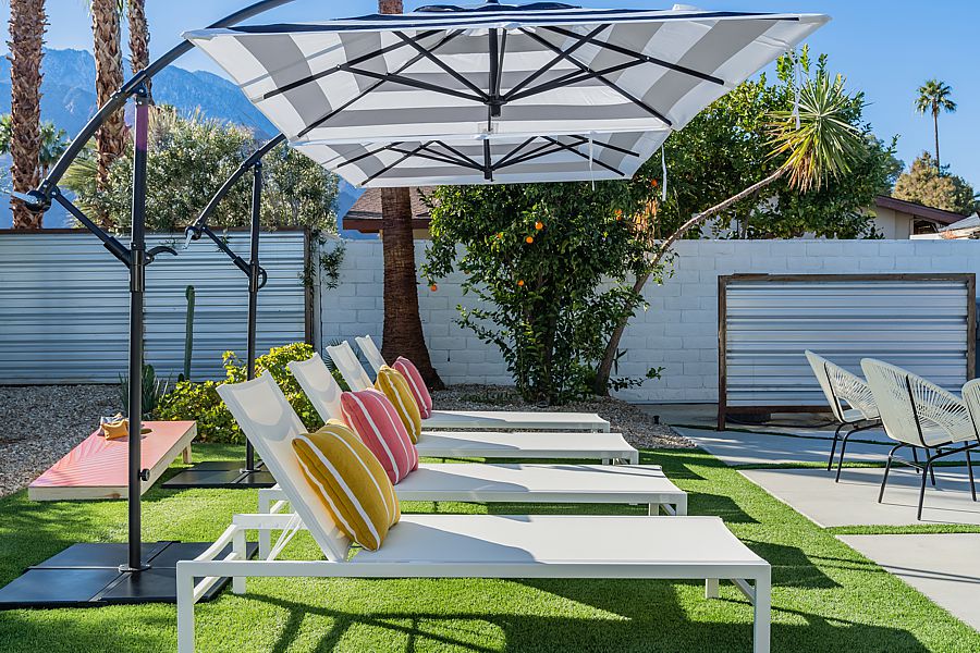 Backyard outdoor chaise lounge chairs with cantilever umbrellas and colorful pillows in California