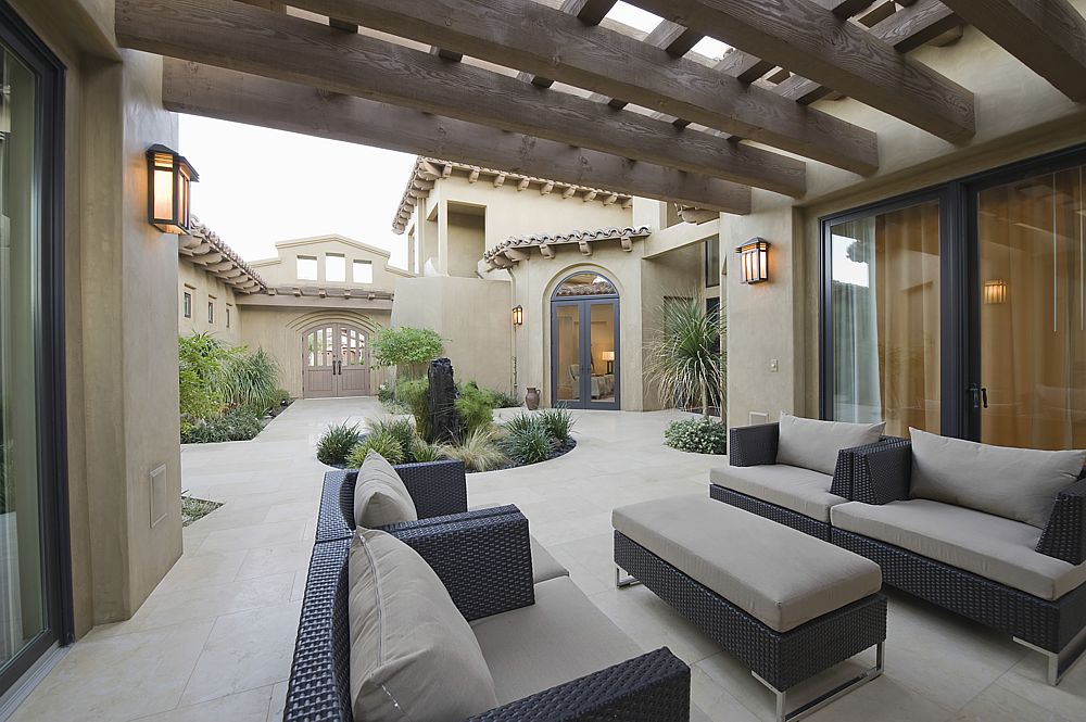 A modern Spanish style home enjoys covered patios in an inner courtyard.